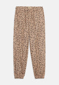 Blumenmuster-Hose mit elastischem Bund und Knöchellöchern. Der Stoff hat einen beigen Hintergrund mit rosa und grünen Blumen.