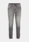 Graue Denim-Jeans im Slim-Fit, mit ausgebleichten Bereichen für Textur, Fünf-Taschen-Design und einem kleinen Logo-Patch auf der vorderen Tasche.