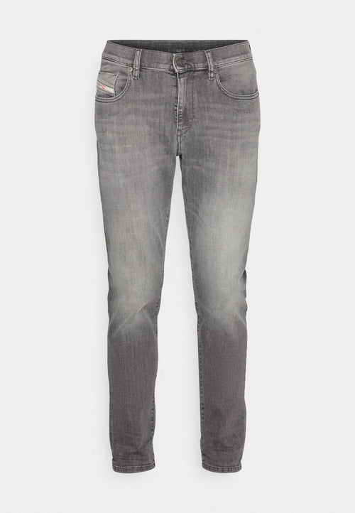 Graue Denim-Jeans im Slim-Fit, mit ausgebleichten Bereichen für Textur, Fünf-Taschen-Design und einem kleinen Logo-Patch auf der vorderen Tasche.