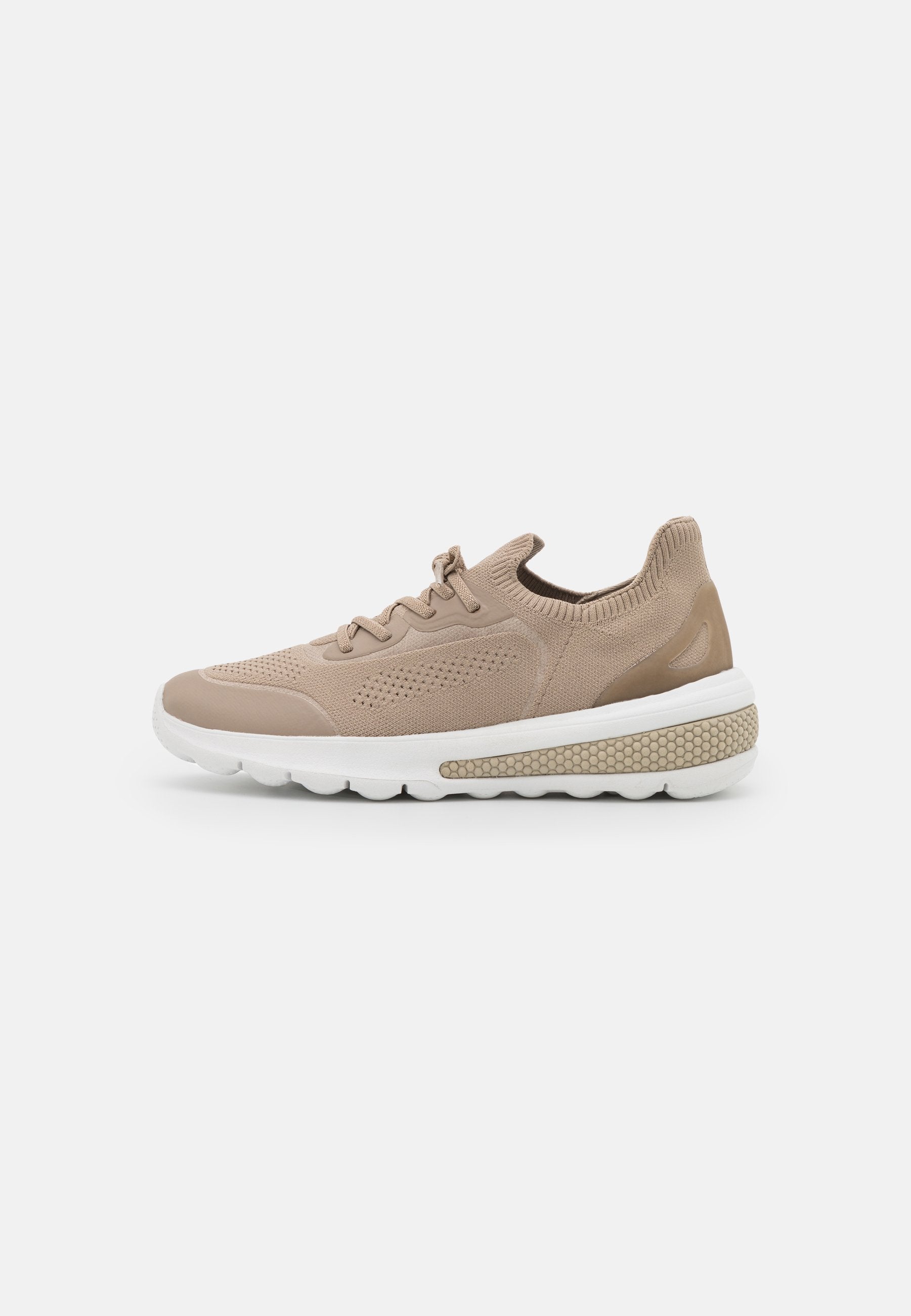Beige Sportchuhe mit einem strukturierten Strickobermaterial, runder Zehenpartie, elastischen Schnürsenkeln und einer weißen, gepolsterten Sohle mit einem gemusterten Akzent.