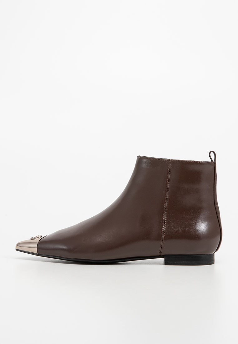 Braune Leder-Stiefelette mit einer metallischen, spitz zulaufenden Zehenkappe und niedrigem schwarzen Absatz, seitlich auf einem weißen Hintergrund dargestellt.