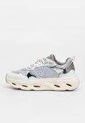 Weißer und silberner Sneaker mit niedrigem Schaft, Mesh- und glänzenden Einsätzen, dicker Sohle mit ausgeschnittenen Lüftungsöffnungen, Schnürung vorne und seitlichem Emblemlogo.