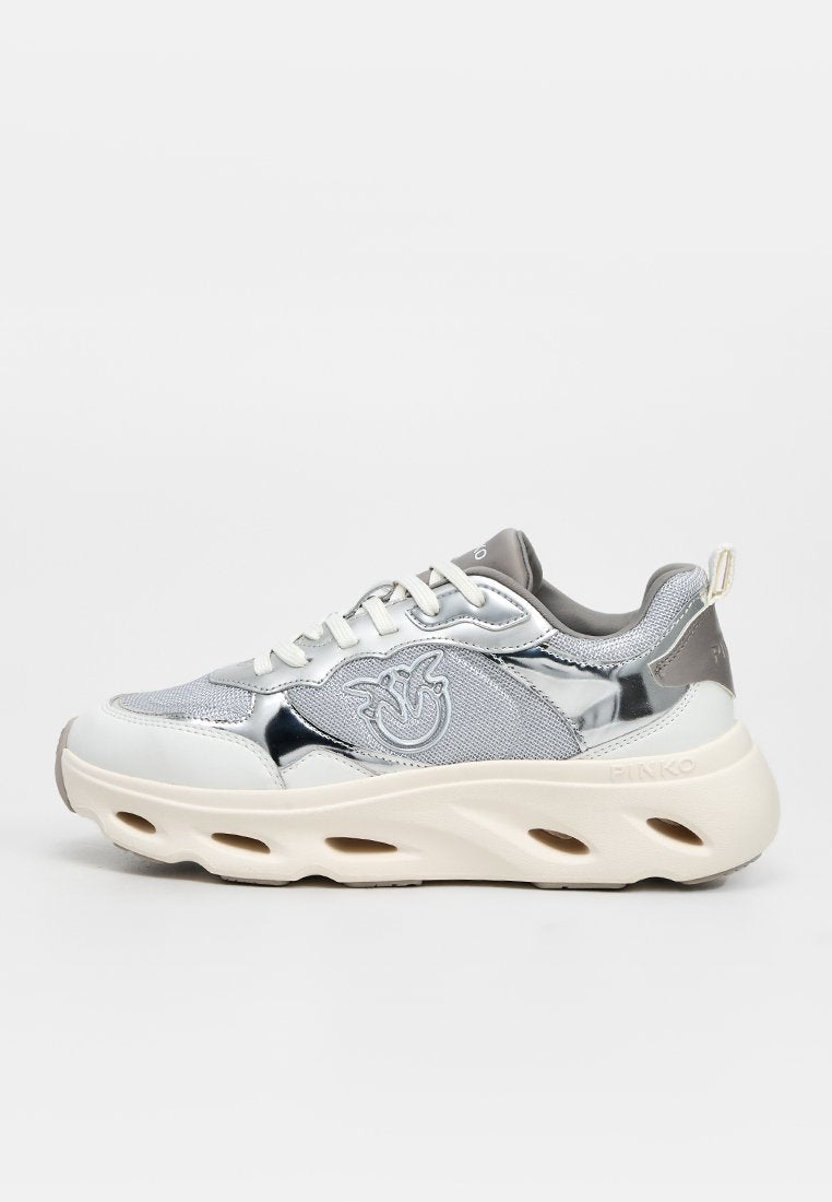 Weißer und silberner Sneaker mit niedrigem Schaft, Mesh- und glänzenden Einsätzen, dicker Sohle mit ausgeschnittenen Lüftungsöffnungen, Schnürung vorne und seitlichem Emblemlogo.