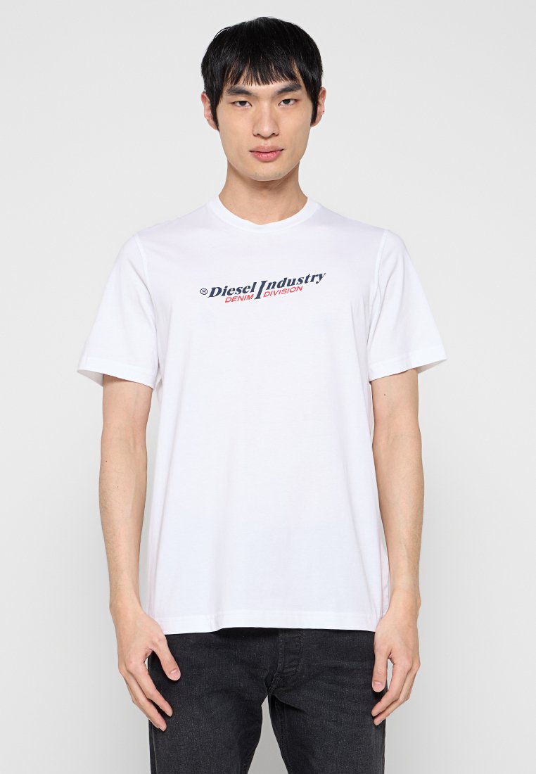 Weißes Baumwoll-T-Shirt mit kurzen Ärmeln, auf der Vorderseite mit "Diesel Industry" und "DENIM DIVISION" in Blau und Rot bedruckt.
