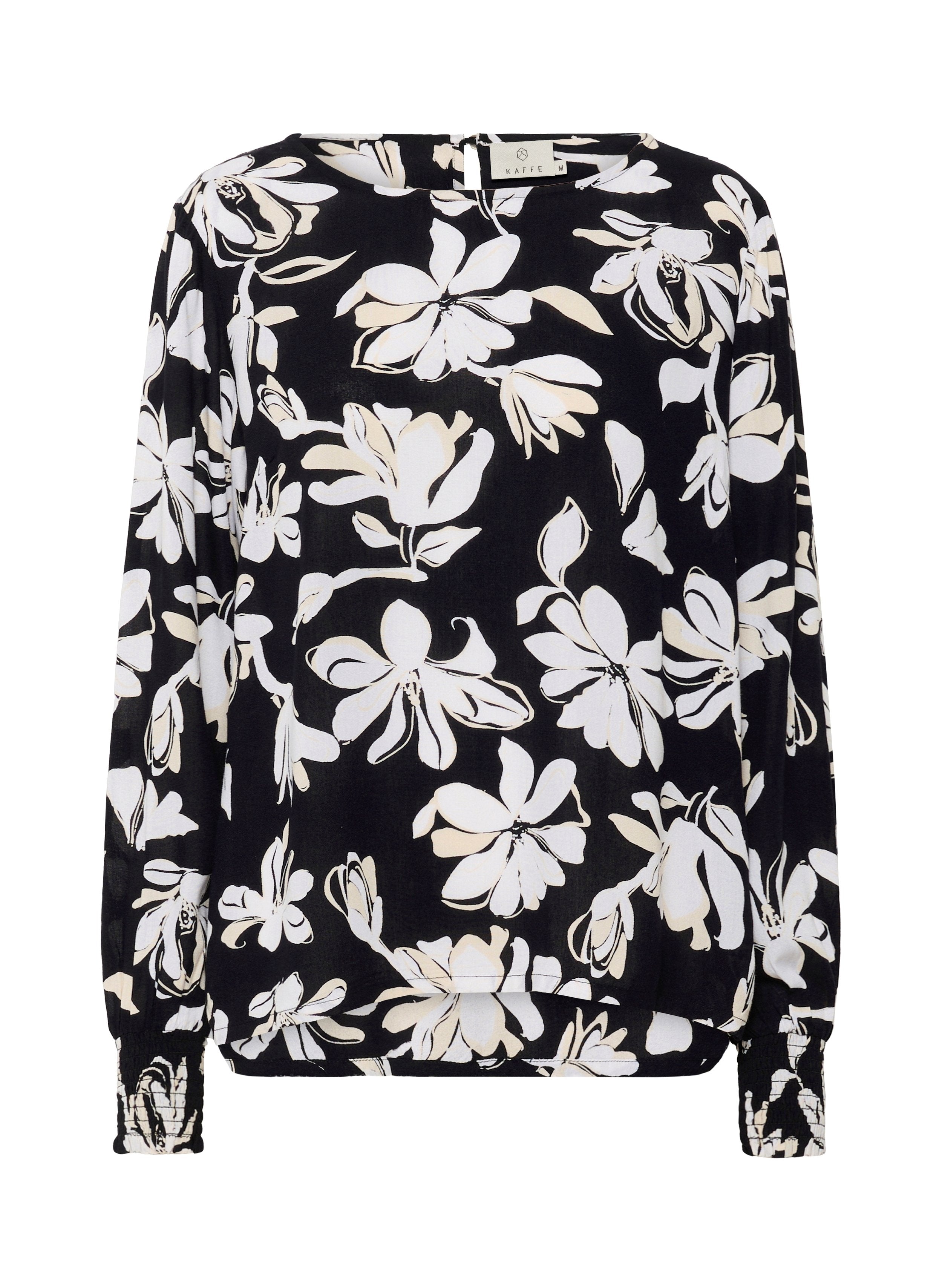 Schwarze Bluse mit weißem Blumenmuster, langen Ärmeln mit gerafften Manschetten, rundem Ausschnitt und leicht durchscheinendem Stoff.