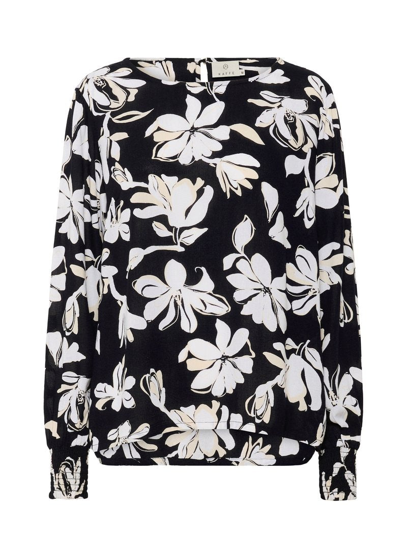 Schwarze Bluse mit weißem Blumenmuster, langen Ärmeln mit gerafften Manschetten, rundem Ausschnitt und leicht durchscheinendem Stoff.