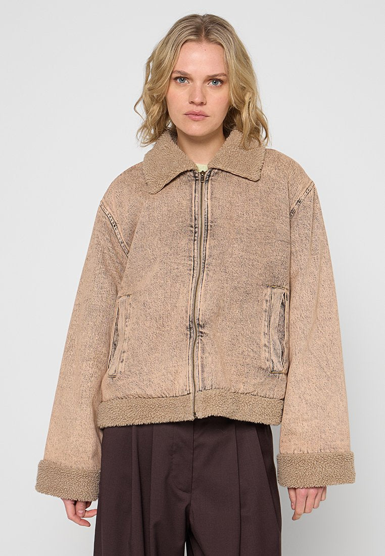 Beige kurzes Jackett mit einem Pelzbesatz am Kragen und an den Bündchen, ausgestattet mit einem Frontreißverschluss und Seitentaschen, gefertigt aus strukturiertem Denim-Stoff.