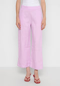 Helle rosa Leinen-Hosen mit weitem Bein, einer glatten Textur, einem hohen Bund und einem lässigen Schnitt, kombiniert mit roten Sandalen.
