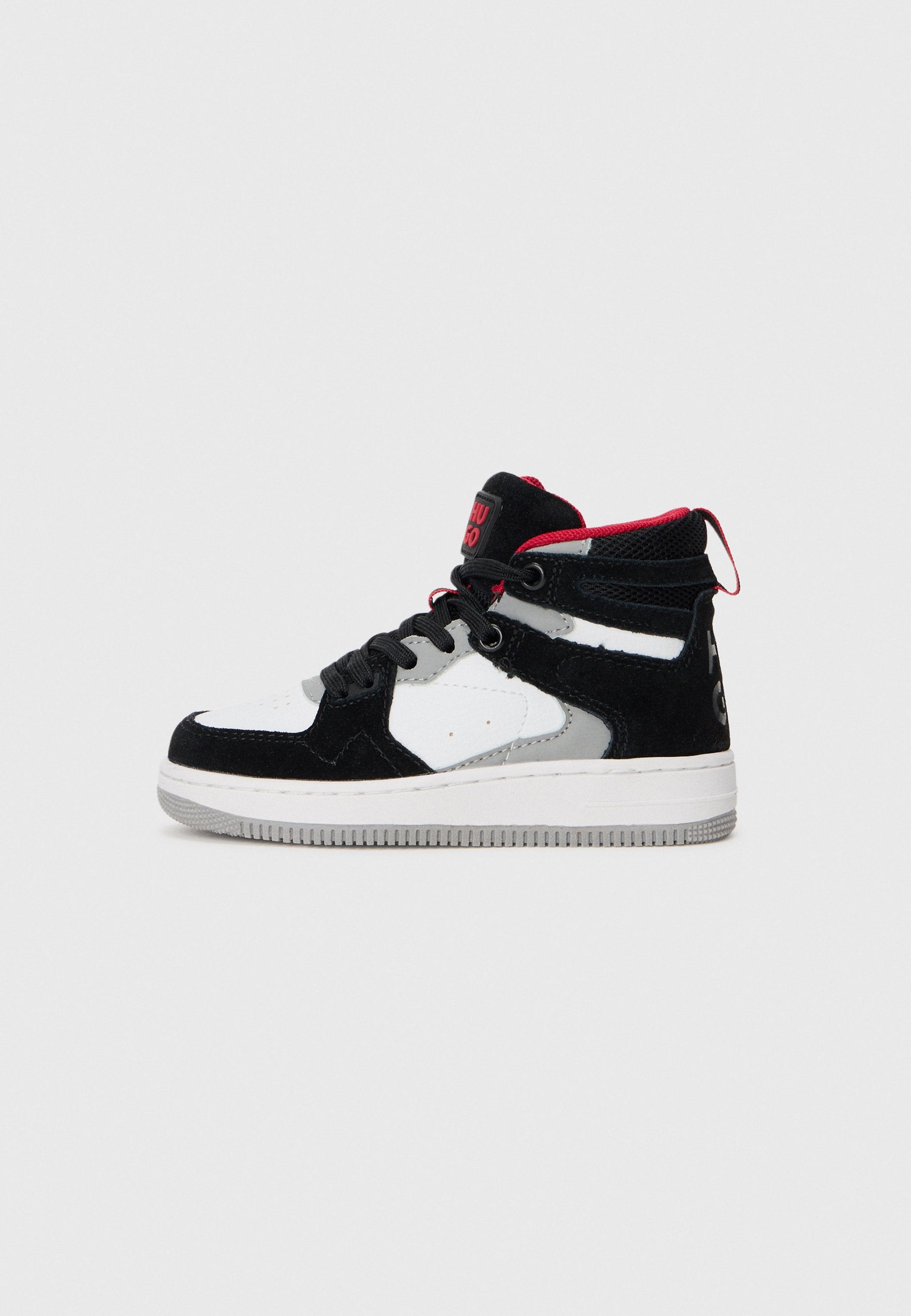 Schwarz-weiße Mid-Top-Sneaker aus Wildleder und Mesh-Materialien. Mit roten Akzenten, grauen Details und einer strukturierten Gummisohle.