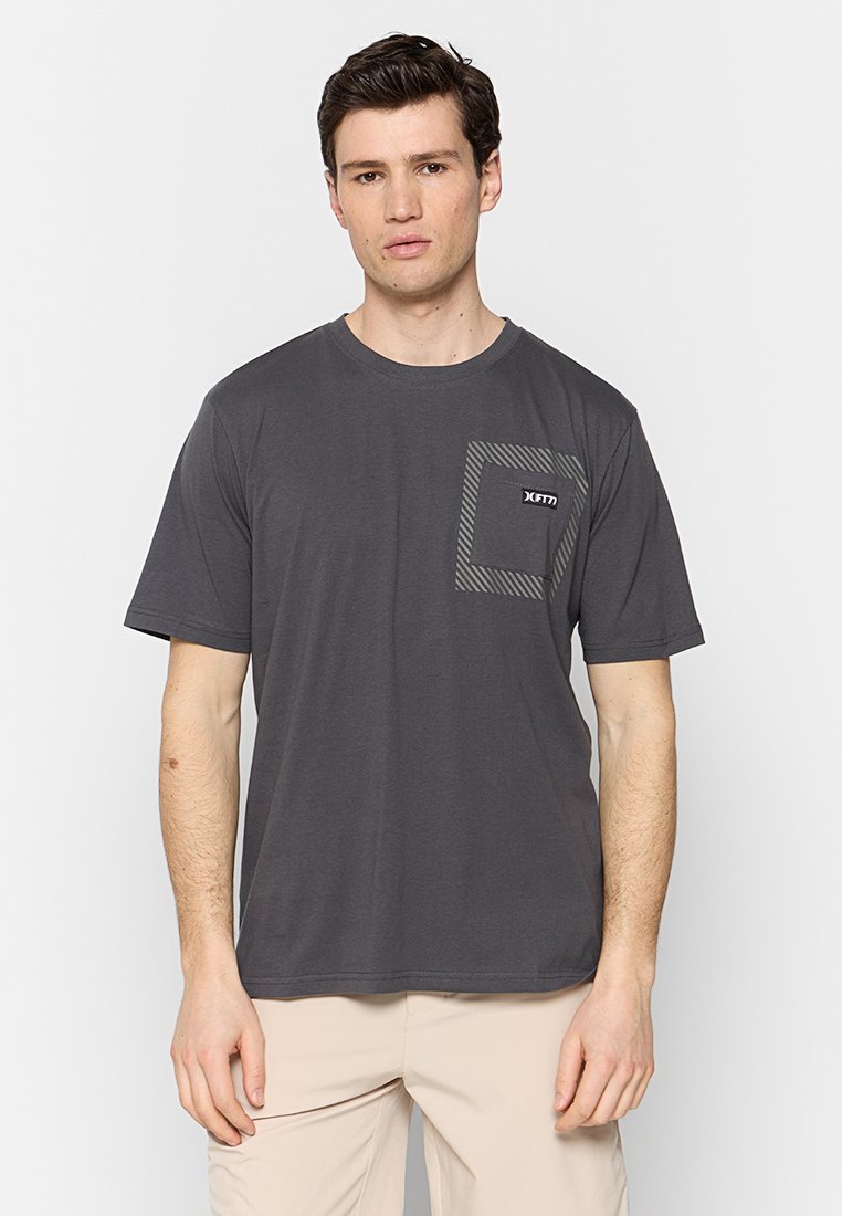 Graues T-Shirt mit kurzen Ärmeln aus weichem Stoff, das eine quadratische Tasche mit einem gestreiften Muster und einem Logo auf der oberen linken Seite hat.