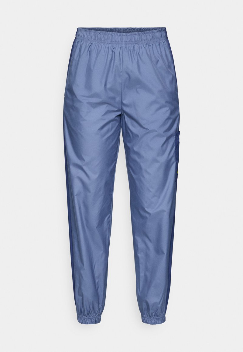 Helleblaue, glänzende Sporthose mit elastischem Bund, schmal zulaufenden Beinen und Seitentasche; aus glattem, leichtem Material gefertigt.
