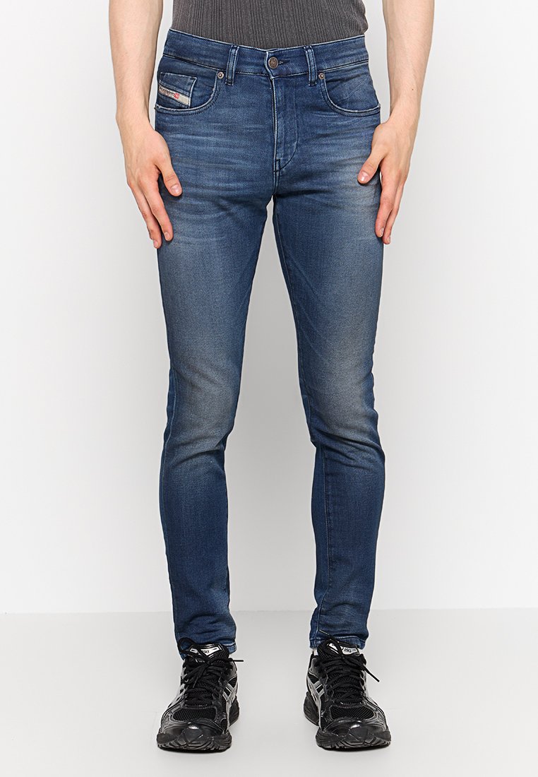 Dunkelblaue Denim-Jeans mit taillierter Passform, mit verblassten Details, Fünf-Taschen-Design und einem kleinen Markenetikett auf der Vorderseite der Tasche.