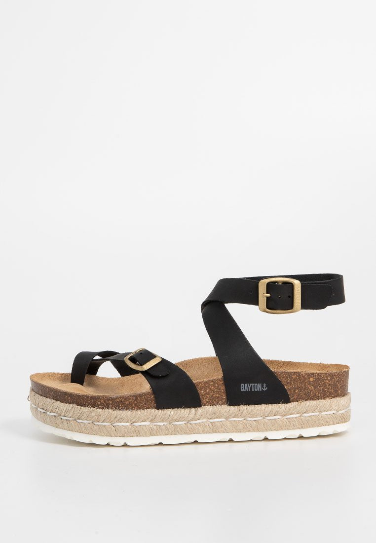 Schwarze Plattformsandalen mit breiten Riemen, Goldbuckle-Akzenten und einem Korkfußbett. Die Sohle verfügt über ein gewebtes Jute-Design für Struktur.