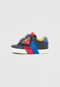 Klettverschluss-Sneaker in Dunkelblau mit roten und blauen Akzenten. Verfügt über ein Superman-Logo-Patch und ein gelbes Innenfutter. Gummisohle.