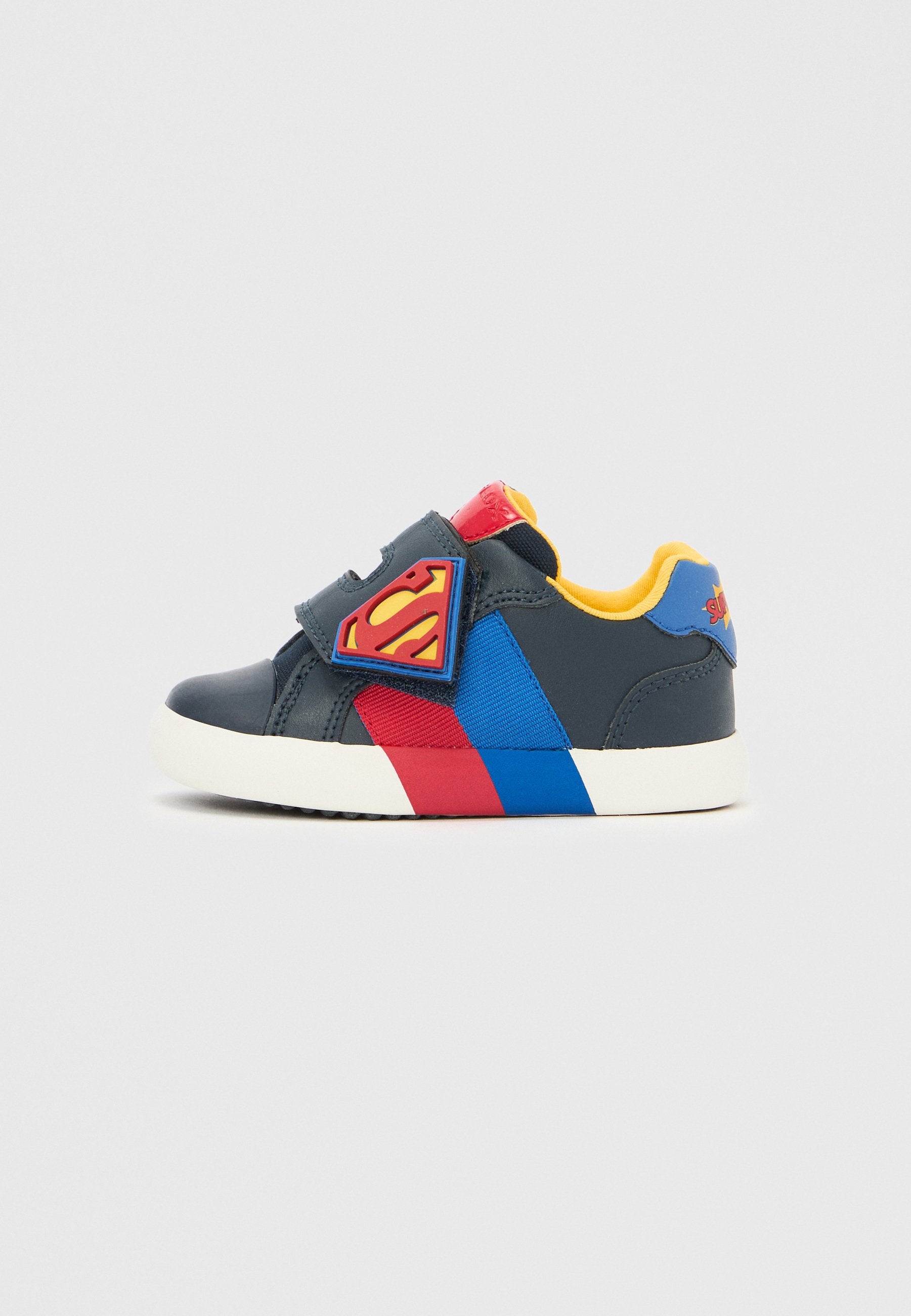Klettverschluss-Sneaker in Dunkelblau mit roten und blauen Akzenten. Verfügt über ein Superman-Logo-Patch und ein gelbes Innenfutter. Gummisohle.