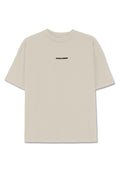 Helles beiges Baumwoll-T-Shirt mit kurzen Ärmeln, lässiger Passform und einem schwarzen "PEGADOR"-Logo auf der Vorderseite. Glatte Textur, Rundhalsausschnitt.