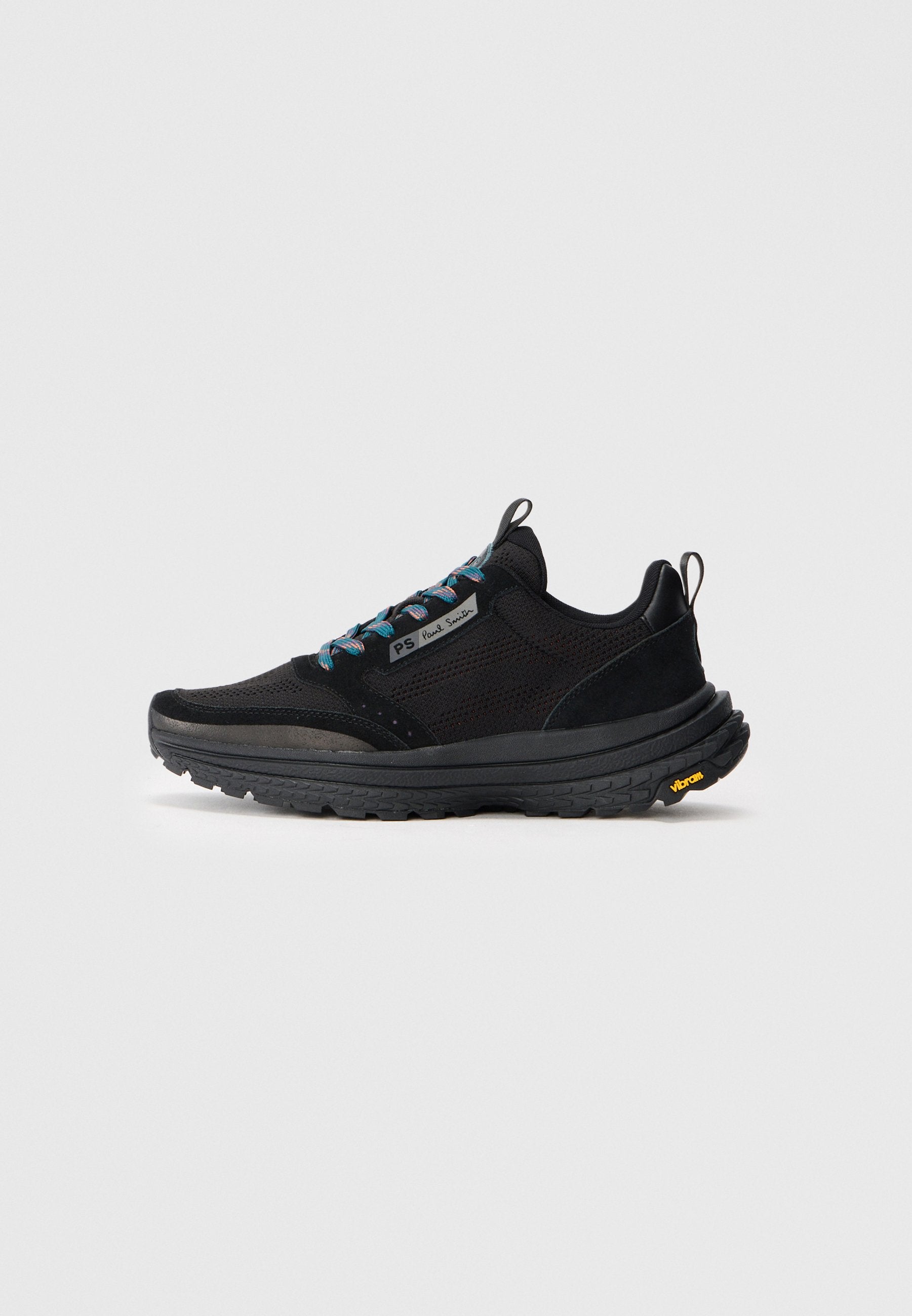 Schwarze Sport Schuhe mit einem Mesh-Obermaterial, Wildleder-Akzenten, bunten Schnürsenkeln und einer strukturierten Gummisohle mit gelbem Vibram-Logo.