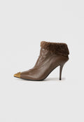 Braune Leder-Ankle-Boots mit einem flauschigen braunen Schaft, spitzer Zehenpartie mit einem metallisch goldenen Tipp und einem Stiletto-Absatz.