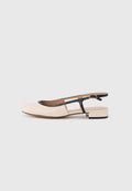 Lederslingback-Schuh mit beigem Vorderteil, schwarzem Besatz und kleinem Blockabsatz. Verfügt über einen offenen Rücken und ein Cut-out-Design.