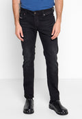 Schwarze Denim-Jeans mit Slim-Fit, mit mittelhohem Bund, klassischem Fünf-Taschen-Design und subtiler Verwaschung. Kombiniert mit schwarzem Schuhwerk.