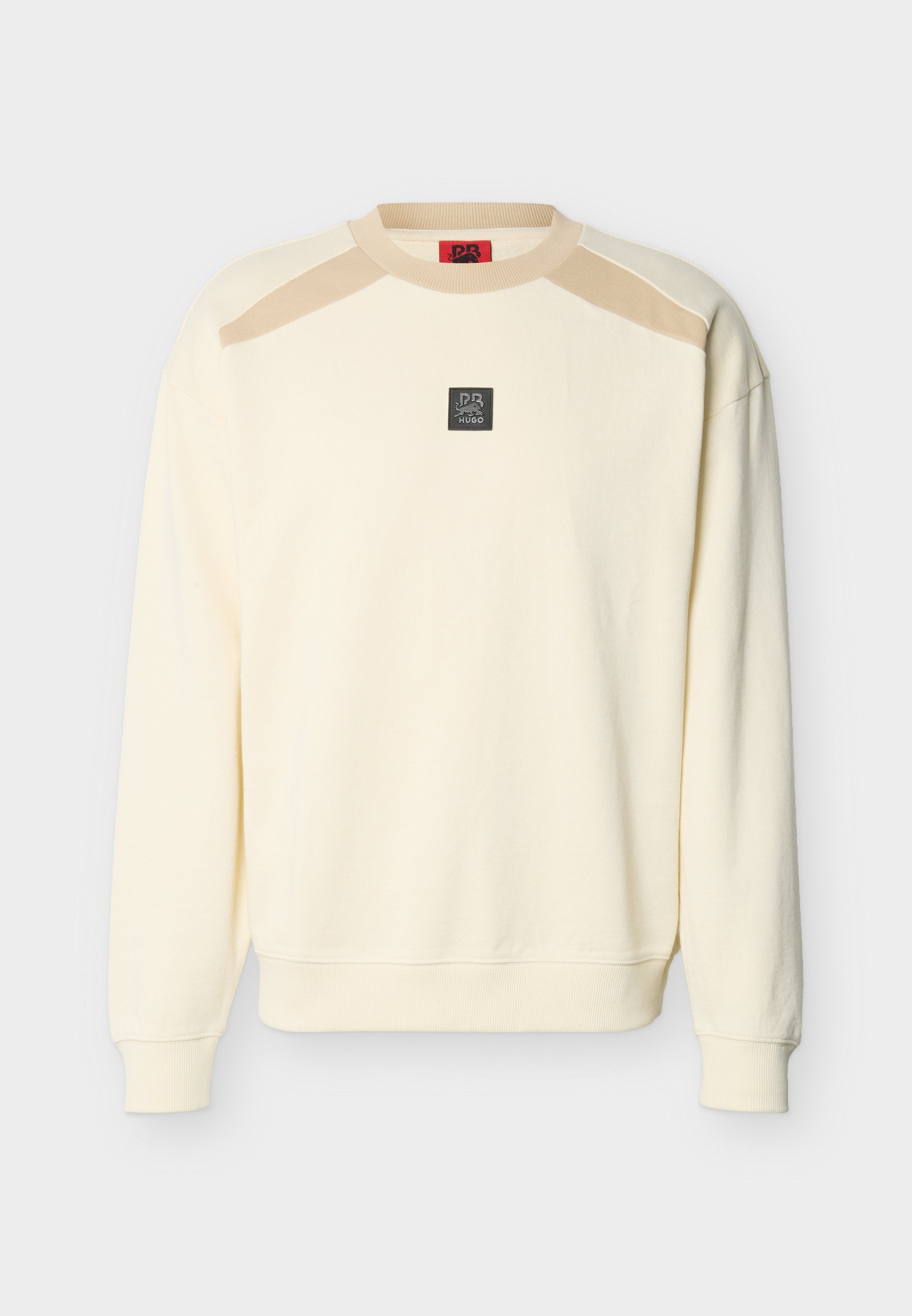 Cremefarbener Langarm-Sweatshirt mit beigen Schulterakzenten und einem kleinen schwarzen quadratischen Logo-Patch in der Mitte der Brust.