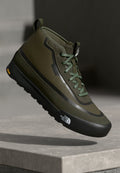 Grüner High-Top-Sneaker mit strukturiertem Obermaterial, Gummisohle, Schnürverschluss und Logo an der Seite. Verfügt über ein schlankes, modernes Design.