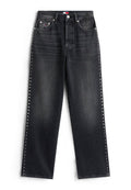 Schwarze Jeans aus Denim mit einer lockeren Passform, die silberne Nietenakzente entlang der Seitennähte und ein klassisches Fünf-Taschen-Design aufweisen.