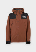 Braune Jacke zum Reißverschluss mit einem schwarzen oberen Bereich, verstellbarer Kapuze und Logo auf der Brust. Verfügt über Druckknöpfe und elastische Bündchen.