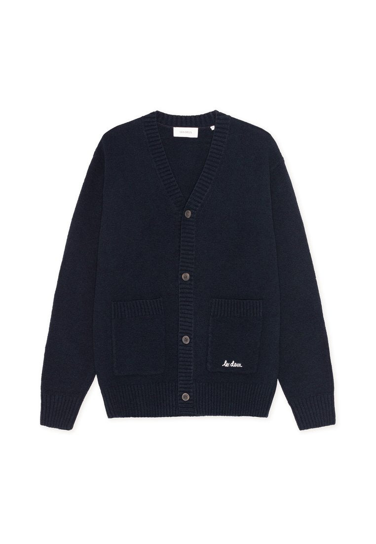 Marineblaue Wolljacke mit V-Ausschnitt, gerippten Bündchen und zwei vorderen Taschen. Mit fünf Knöpfen und einem kleinen weißen gestickten Logo.