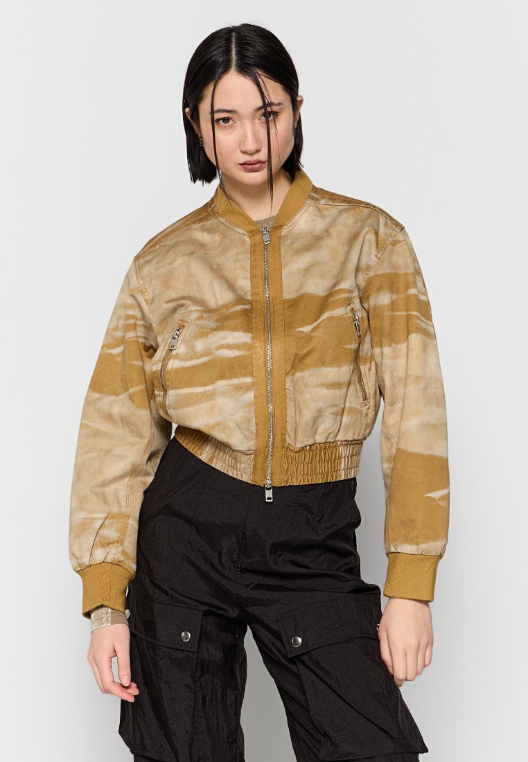 Gefütterte Bomberjacke in Beige mit einem marmorierten Muster. Mit einem Reißverschluss vorne, gerippten Bündchen und zwei Reißverschlusstaschen vorne.
