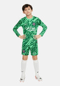 Grünes Fußballtrikot mit langen Ärmeln und Shorts, das ein Wellenmuster, das Qatar Airways-Logo und das Paris Saint-Germain-Wappen zeigt. Weiße Socken und Stiefel.
