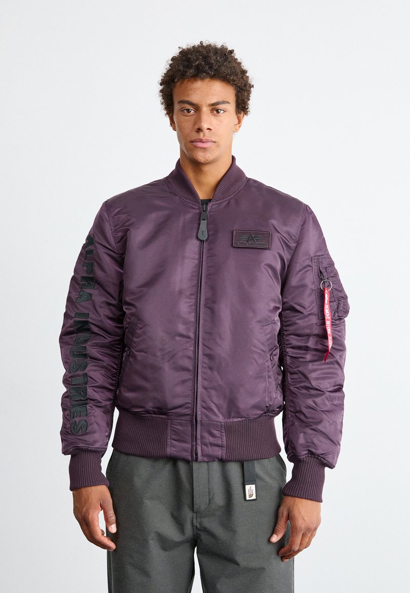 Lila Bomberjacke aus glänzendem Nylon, mit geripptem Kragen und Bündchen, Reißverschluss, seitlichen Taschen und einem Logo-Patch auf der Brust.