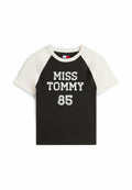 Schwarzes T-Shirt mit kurzen weißen Raglanärmeln, vorne mit dem Schriftzug "MISS TOMMY 85" in fetten, strukturierten weißen Buchstaben.