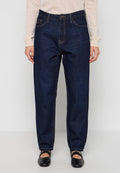 Dunkelblaue Jeans aus Denim mit geradem Schnitt, sichtbaren Nähten, fünf Taschen und einem Knopfverschluss, kombiniert mit schwarzen flachen Schuhen.