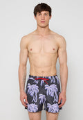 Herrenschwimmshorts aus schwarzem Stoff mit lila Palmenmuster. Mit rotem Kordelzug an der Taille. Normale Passform.