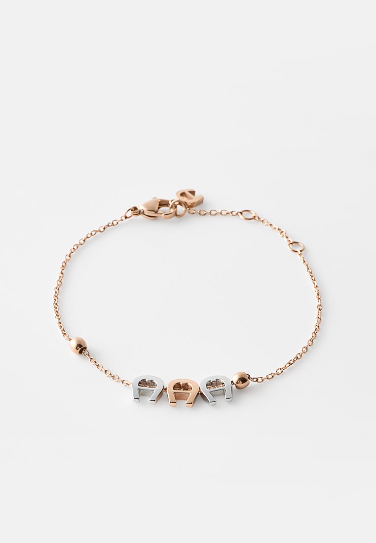 Zarter Armreif aus Roségold mit Gliederkette, Karabinerverschluss und drei Hufeisenanhängern, zwei silberne und ein rosegoldener, getrennt durch kleine Perlen.