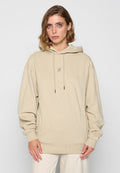 Beige Kapuzenpullover mit lässigem Schnitt, Vordertasche, Kordelzügen und gesticktem Logo. Weiches Material aus Baumwolle mit gerippten Bündchen und Saum.