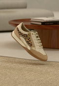 Beiger Sneaker mit Leopardenmuster-Akzenten, goldenen Beschlägen und strukturiertem Wildleder. Verfügt über einen gepolsterten Schaft und eine hellbraune Gummisohle.
