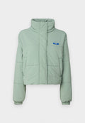 Gepolsterte cropped Jacke in Hellgrün mit hohem Kragen, seitlichen Taschen, elastischen Bündchen und einem blauen Etikett auf der linken Brust.