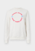 Weißer Sweatshirt mit einem runden Grafikdesign, auf dem "TOMMY JEANS" in Pink und "NEW YORK CITY" darunter steht, ergänzt durch blaue Herzen. Aus weichem Baumwollmaterial.