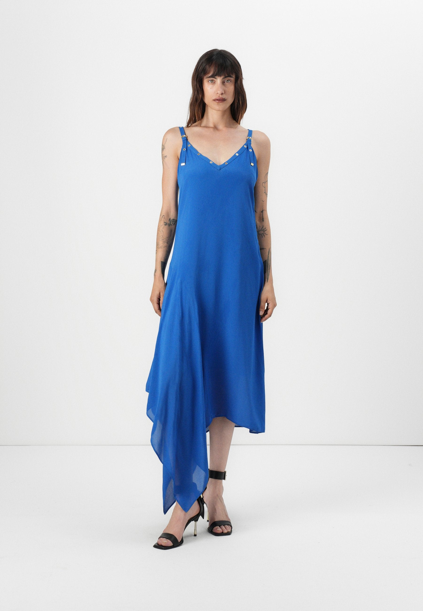 Blaues asymmetrisches Kleid aus leichtem Stoff mit V-Ausschnitt, verstellbaren Trägern mit metallischen Akzenten und fließendem Saum.