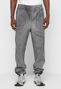 Graue Jogginghosen mit strukturiertem Finish, elastischem Bund und seitlichen Taschen. Am Knöchel schmal zulaufend, kombiniert mit silbernen Sneakers.