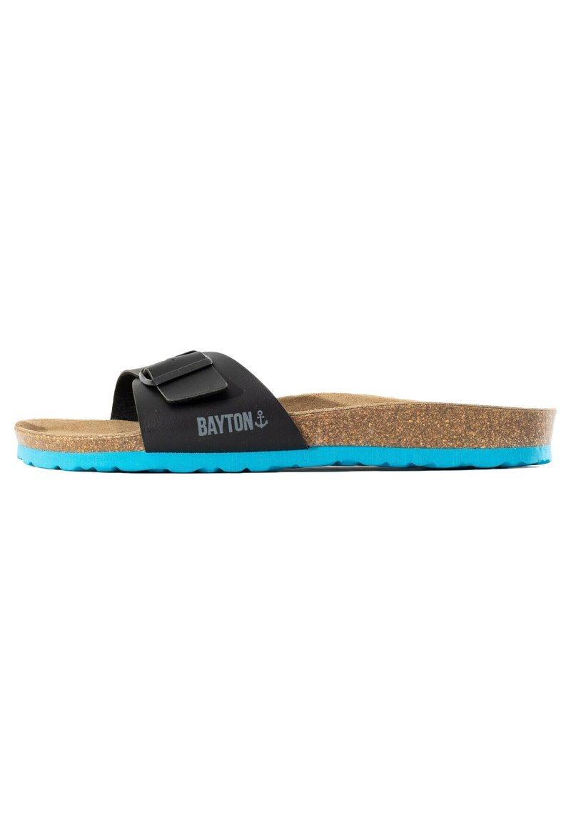 Schwarze Slide-Sandale mit Korkfußbett, verstellbarem Schnallenriemen, blauer Sohle und "BAYTON"-Logo mit Anker an der Seite.