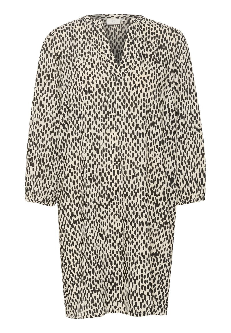 Kleid mit Tiermuster, das einen beigen Hintergrund mit schwarzen unregelmäßigen Flecken aufweist, einen V-Ausschnitt und drei Viertel-Ärmel hat.