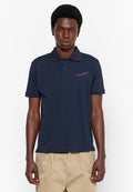 Marineblaues Poloshirt aus Baumwolle, mit einem Kragen mit drei Knöpfen, kurzen Ärmeln und einem kleinen Logo in Rot und Blau auf der linken Brust.