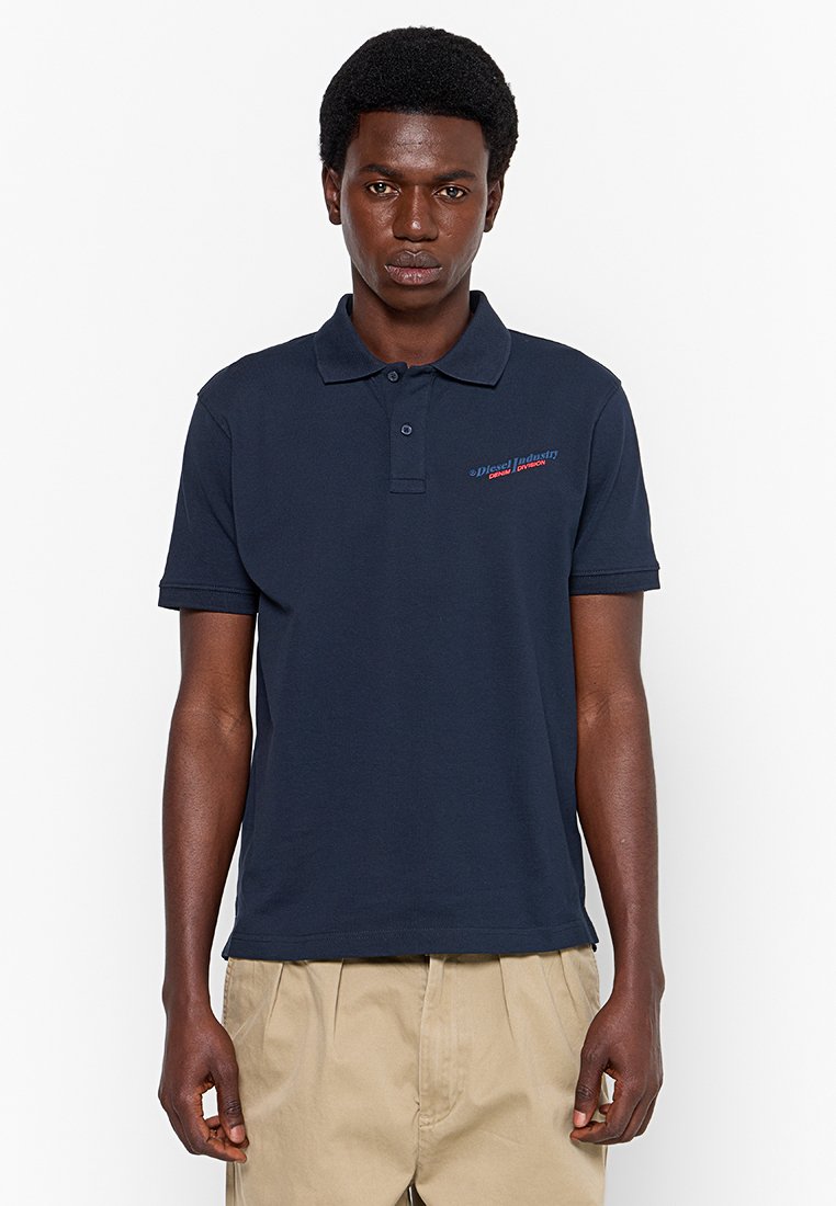 Marineblaues Poloshirt aus Baumwolle, mit einem Kragen mit drei Knöpfen, kurzen Ärmeln und einem kleinen Logo in Rot und Blau auf der linken Brust.