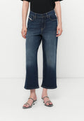 Dunkelblaue Jeans-Hosen mit weitem Bein und verblasstem Finish, ausgestattet mit Gürtelschlaufen, seitlichen Taschen und gesäumtem Saum. Getragen mit Riemchensandalen.