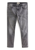 Schmal geschnittene, ausgebleichte graue Jeans mit frontalen Taschen, Gürtelschlaufen und Knopfverschluss, flach auf einem weißen Hintergrund ausgelegt.