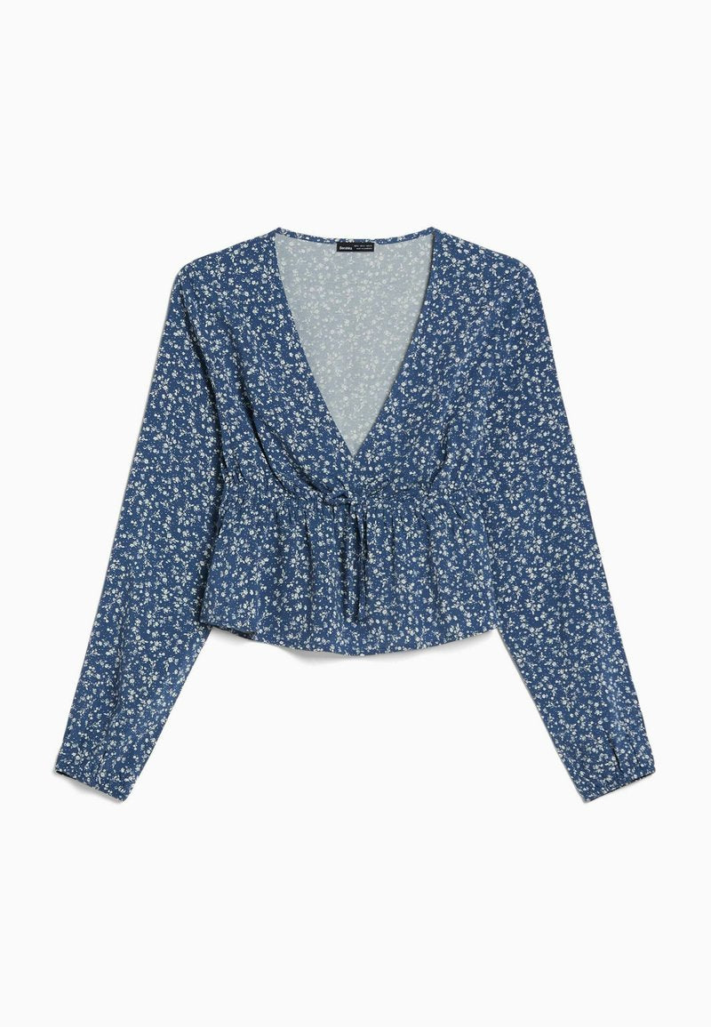 Blaues Blusenoberteil mit langen Ärmeln, tiefem V-Ausschnitt, geraffter Taille und einem Peplum-Saum. Verfügt über kleine, weiße Blumenmuster auf einem strukturierten Stoff.