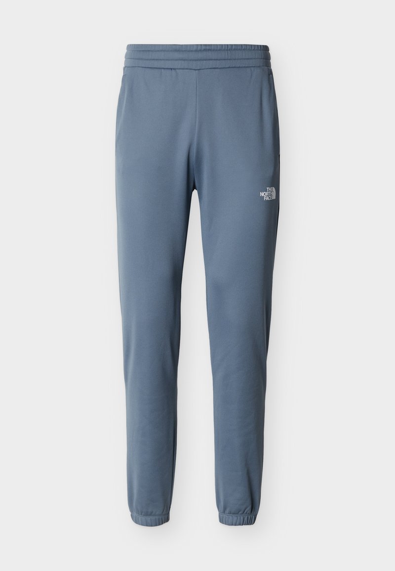 Blaue, eng zulaufende Fleecehose mit elastischem Bund und Bündchen, mit einem kleinen weißen The North Face-Logo am rechten Oberschenkel.